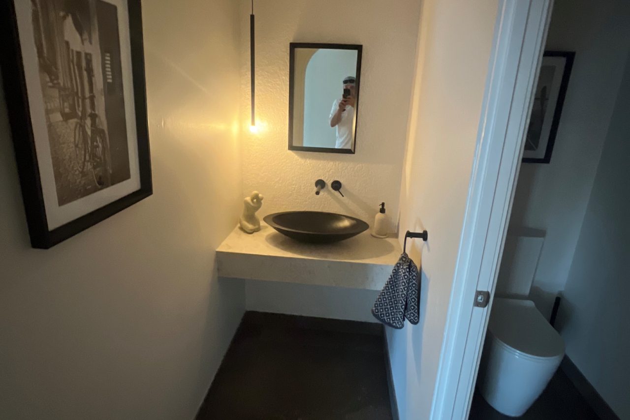 Modern bathroom with black sink and mirror.